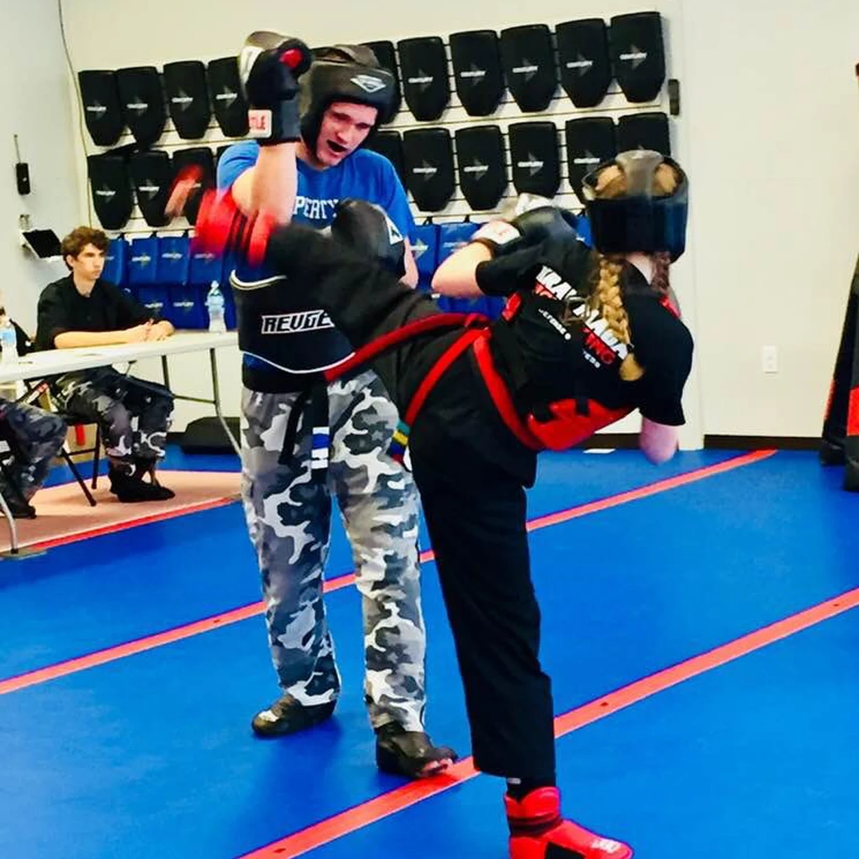 Kids sparring with pads and gear in a kids martial arts class in Grand Rapids